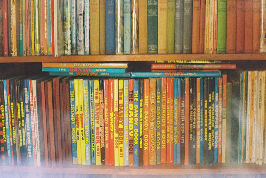 Stack of old books with worn spines on a shelf